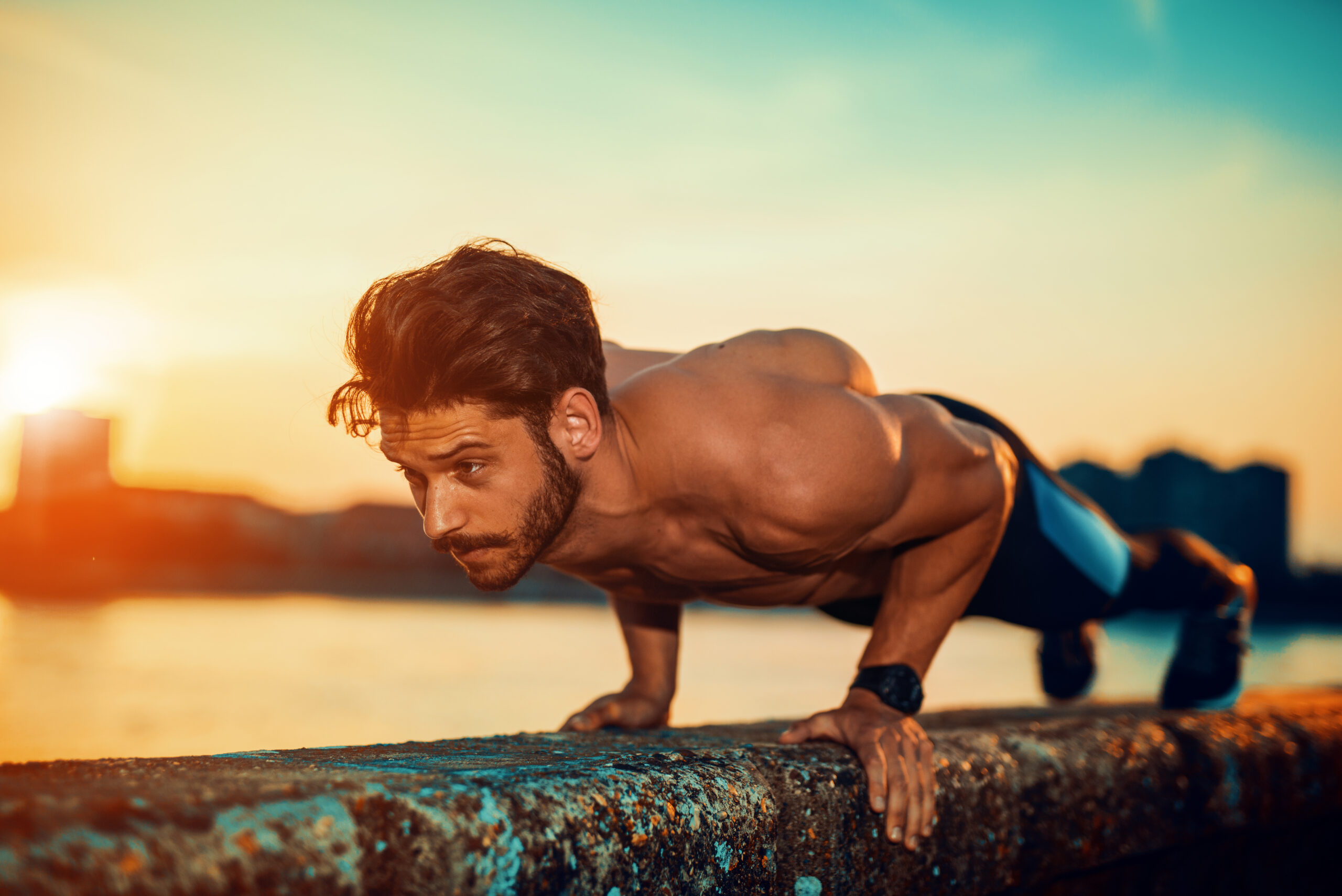 Portrait of a fitness man doing push ups outdoors.